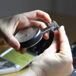 Mary carrying out a preliminary examination of a sapphire and diamond ring.
